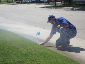 a Rockville Sprinkler Repair team member adjusts a pop up head